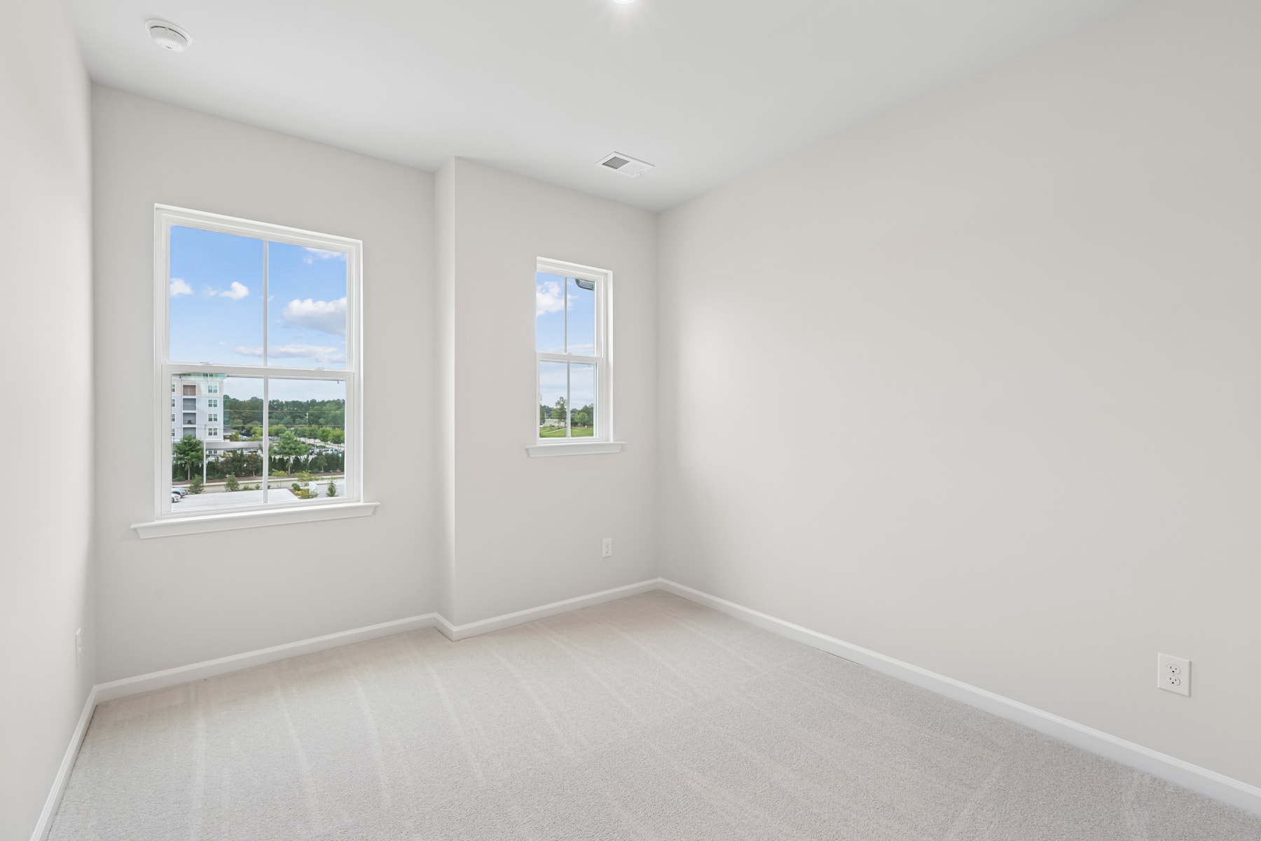 A bright and airy room with large windows overlooking a scenic outdoor landscape.