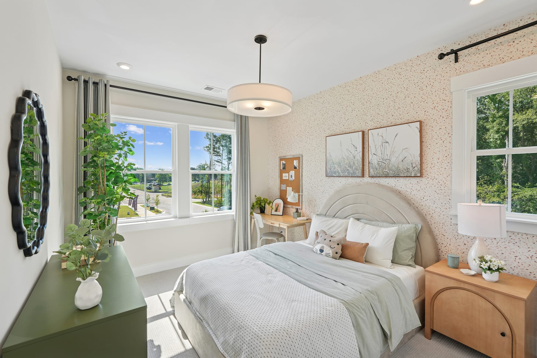 A cozy and inviting bedroom with a large window overlooking a lush outdoor scene, featuring a plush bed, wooden furniture, and decorative accents that create a warm and serene atmosphere.