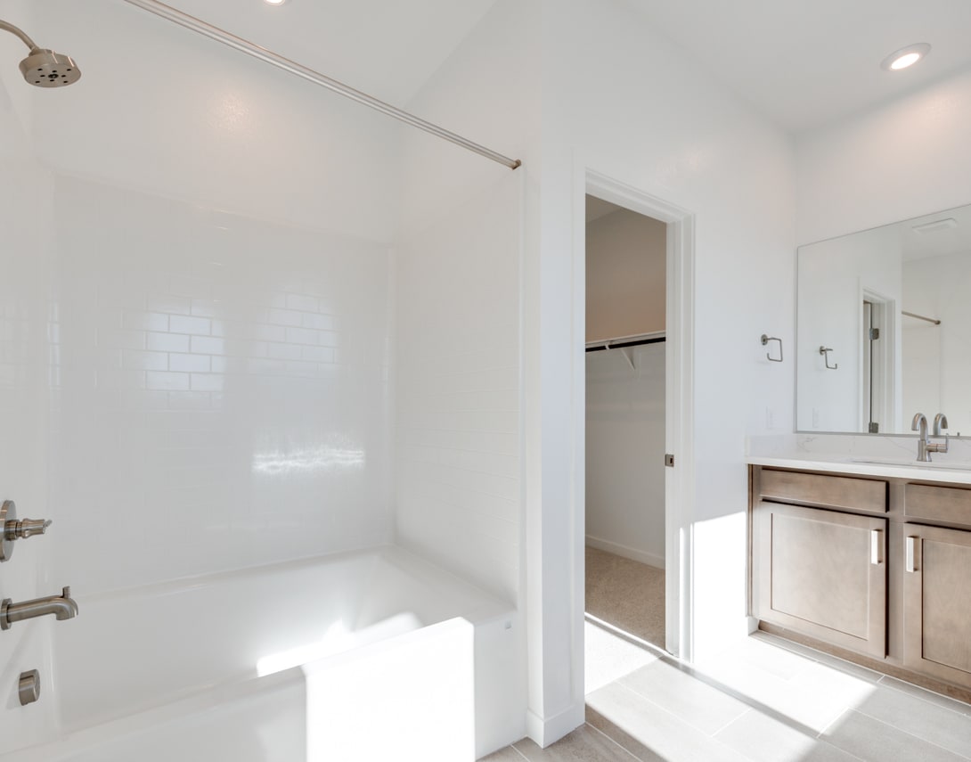 A bright and spacious bathroom with a large shower enclosure, a vanity unit, and a mirror on the wall.