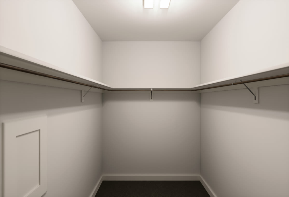 A simple, minimalist closet space with white walls, a ceiling light, and metal hanging rods for storage.