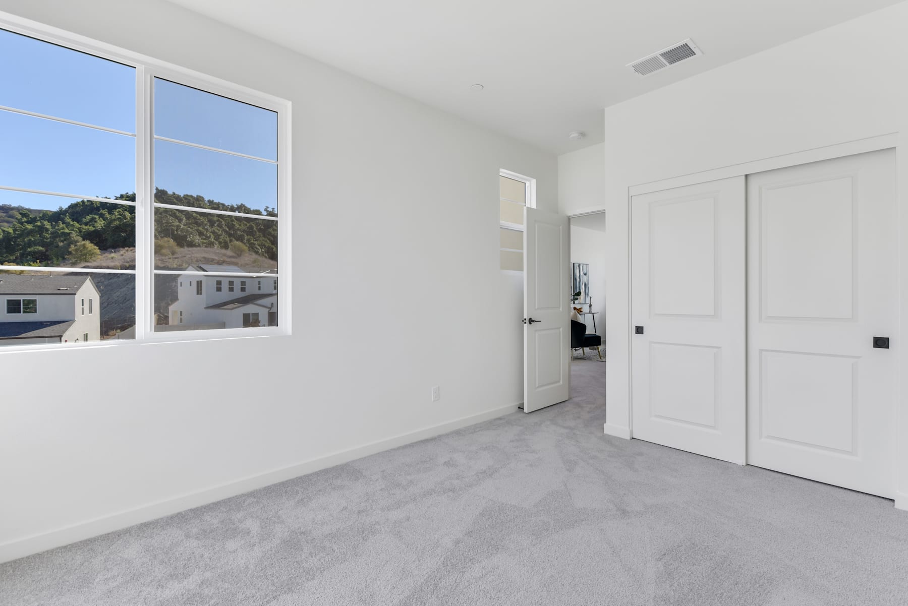 A bright and spacious room with large windows overlooking a scenic outdoor landscape.