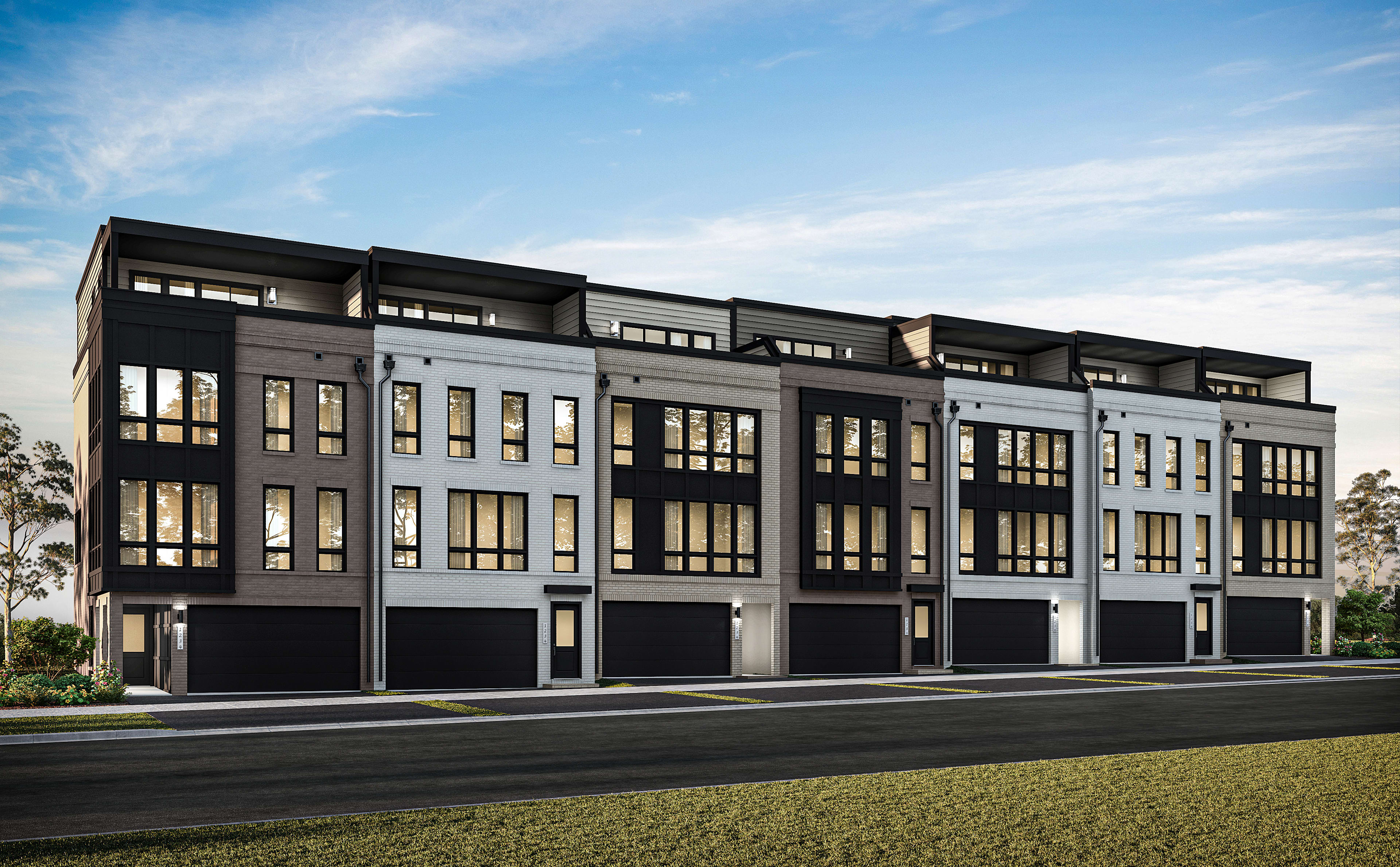 A modern multi-story residential building with a sleek, contemporary design stands against a backdrop of a clear blue sky with wispy clouds.