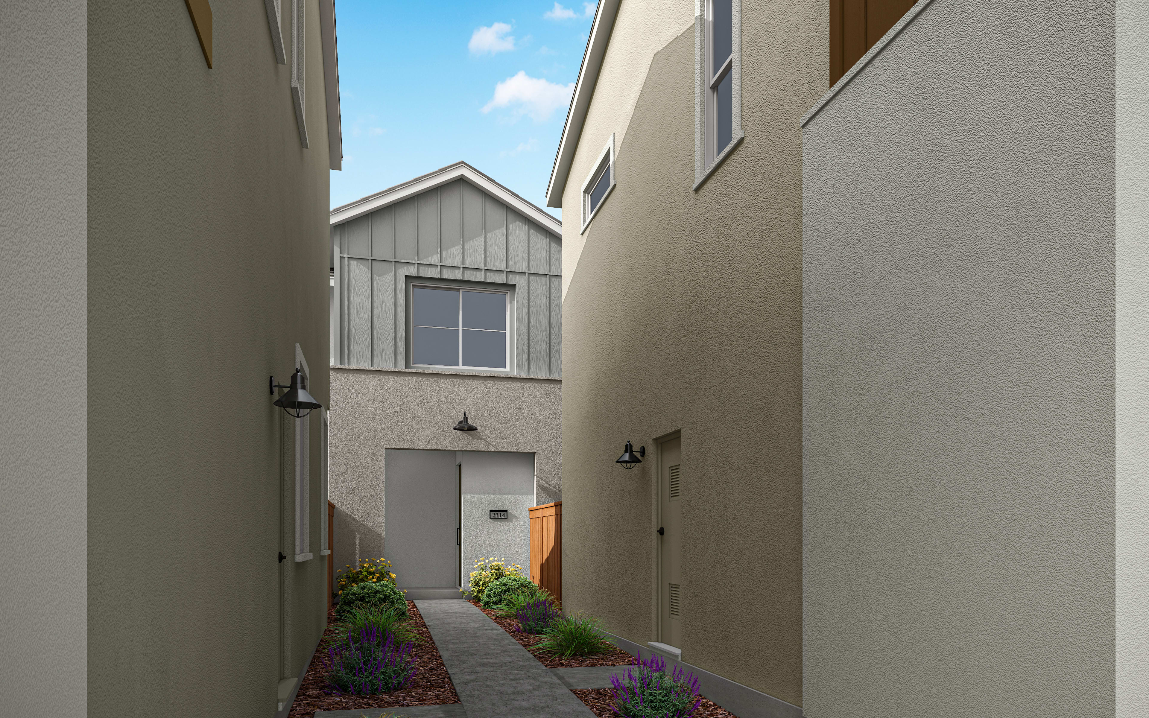 A narrow alleyway between two buildings, with a gray-sided structure in the background and a small garden area in the foreground.