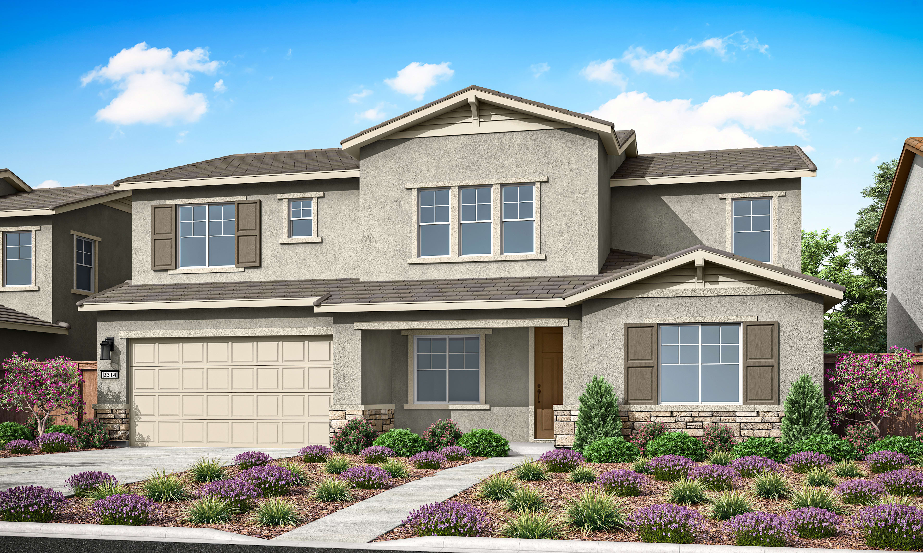 A two-story residential house with a gray exterior, a gabled roof, and a well-landscaped front yard featuring purple flowers and other greenery against a clear blue sky with fluffy white clouds.