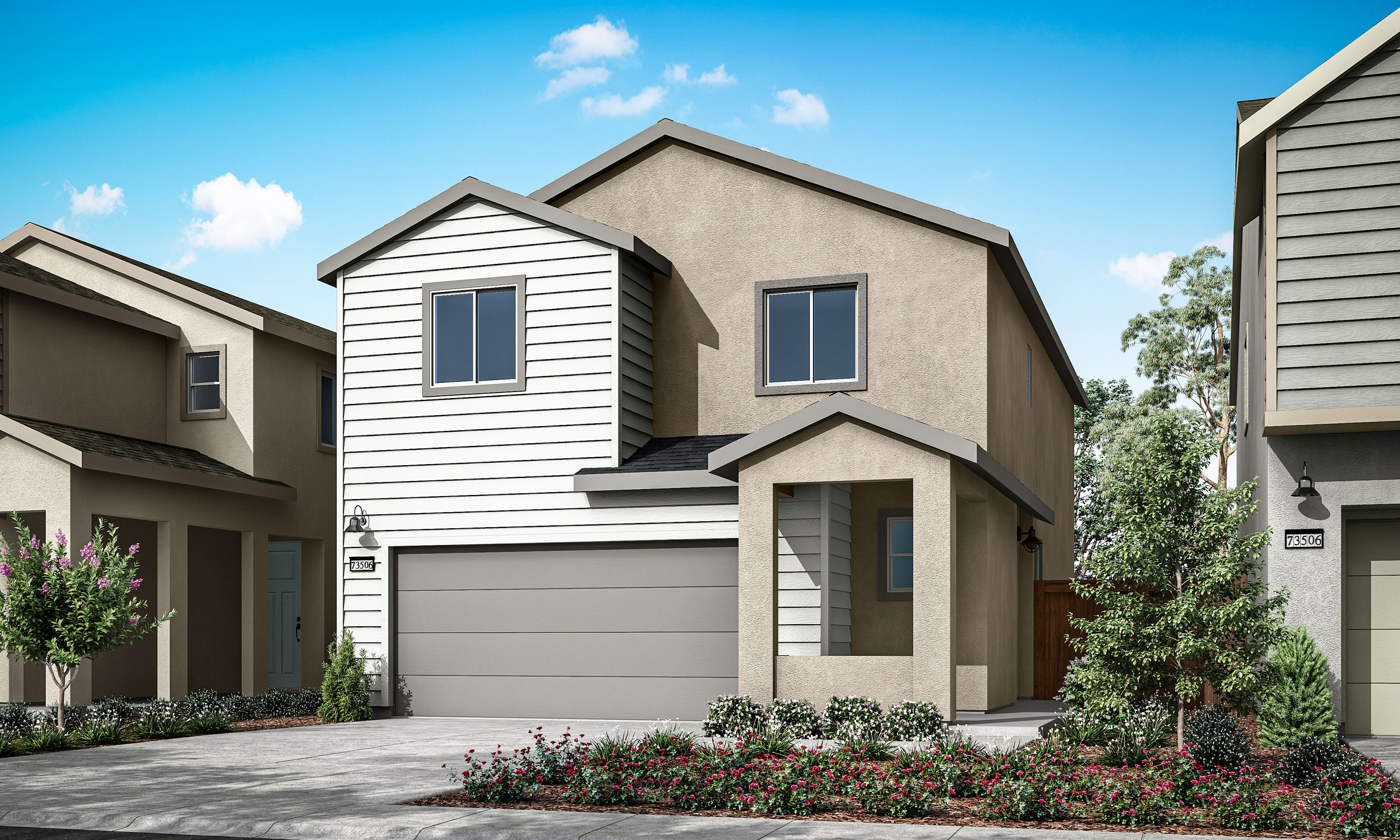 A modern two-story house with a gray exterior, a black garage door, and a well-landscaped front yard with colorful flowers against a backdrop of blue sky and lush greenery.