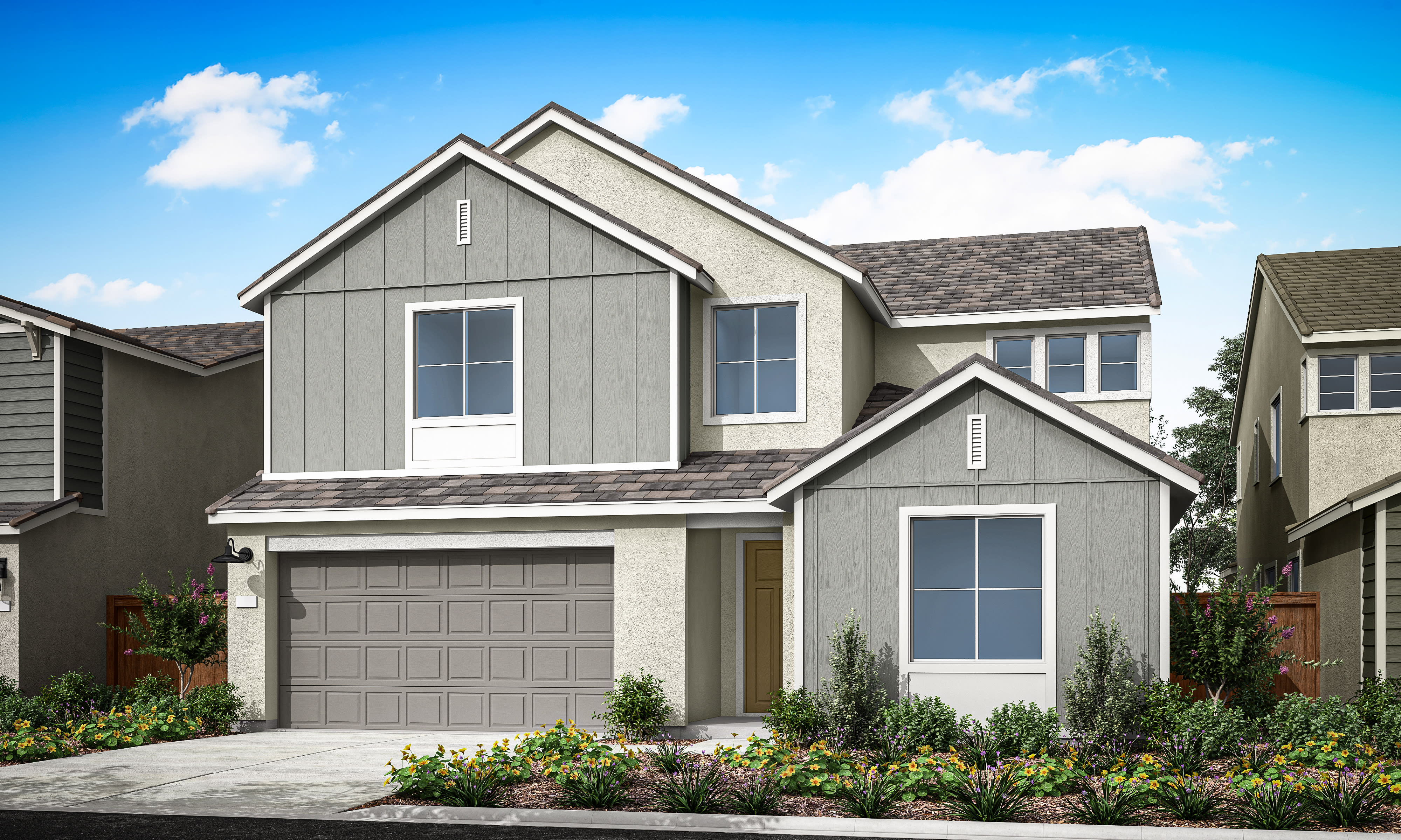 A two-story residential house with a gray exterior, a garage, and a well-landscaped front yard set against a clear blue sky with fluffy white clouds.
