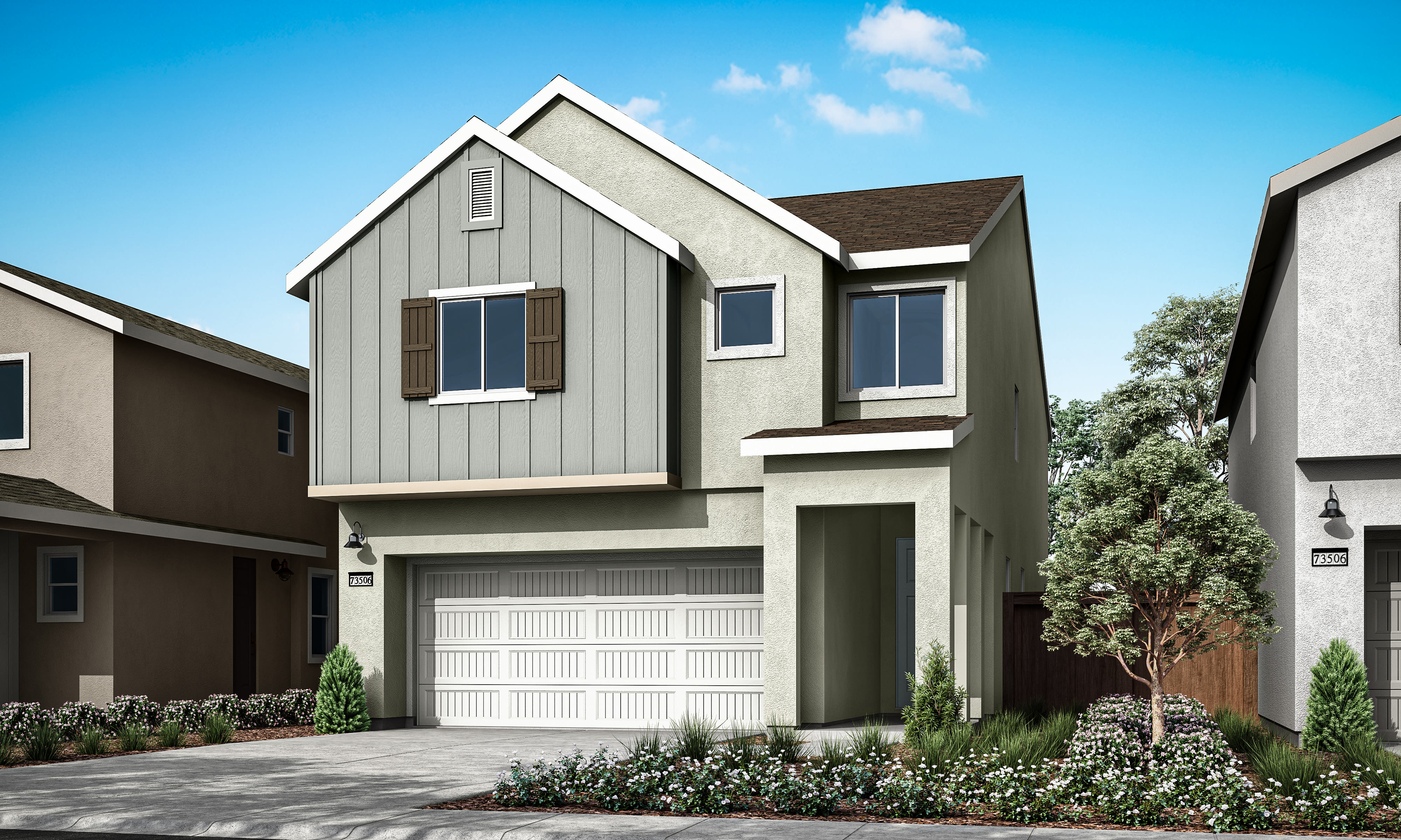 A modern two-story house with a gray exterior, a garage, and a well-landscaped front yard with flowers and shrubs against a clear blue sky.
