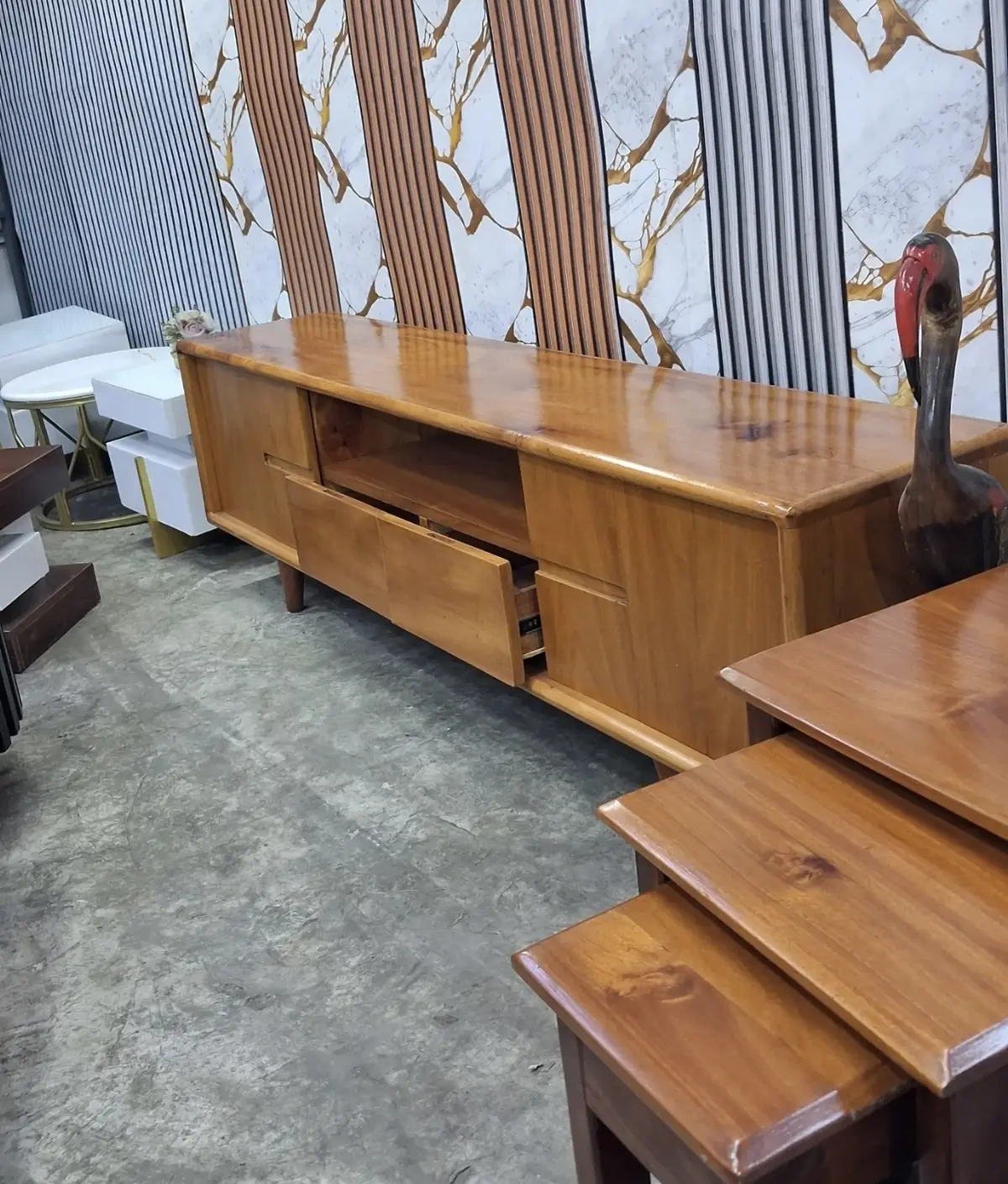 Long low solid wood TV stand sized for a large screen in a Kenyan living room