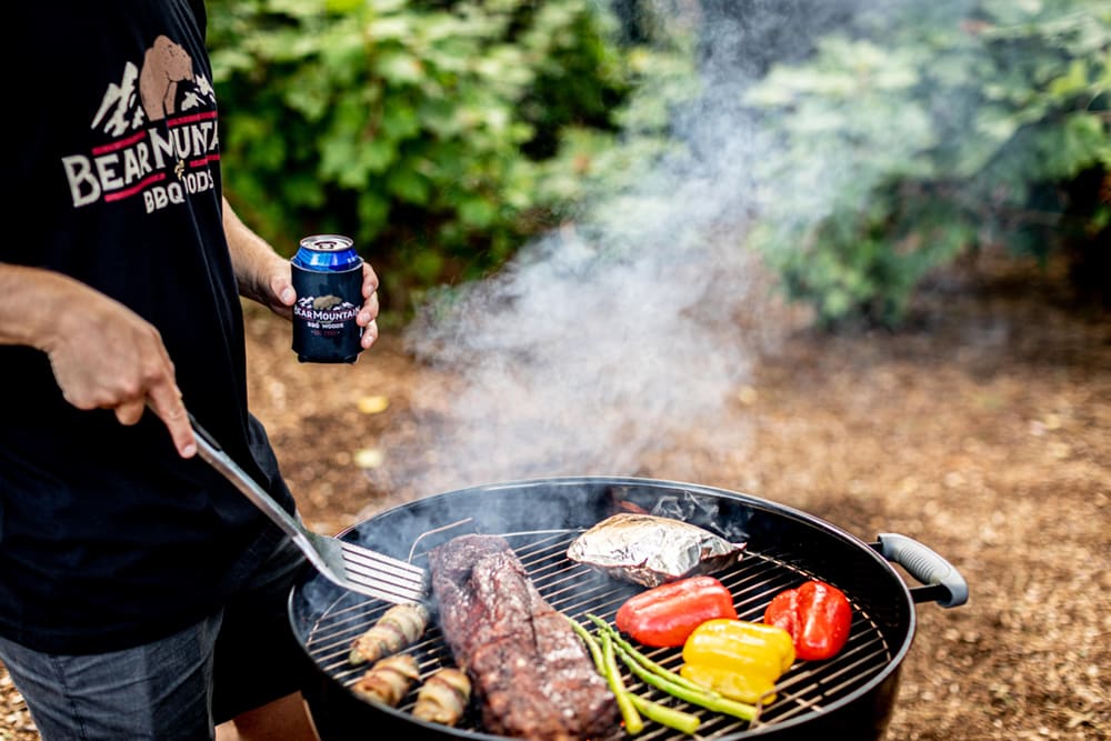 photo of man grilling meat and vegetables
