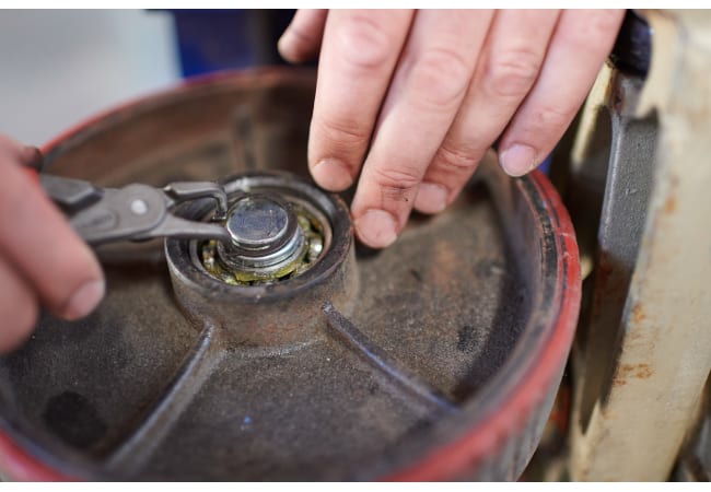 Mitarbeiter Werkstatt wechselt Hubwagenlenkrolle