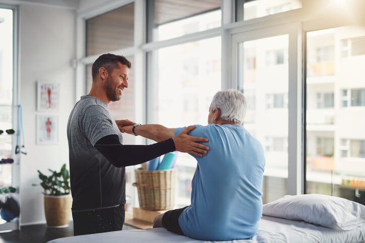 Physical therapist helps his patient with rehab in rehab center