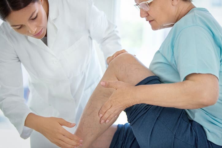 Doctor examines a patient's varicose veins for treatment