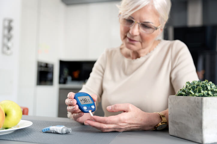 Woman uses test strip and glucometer to check blood sugar