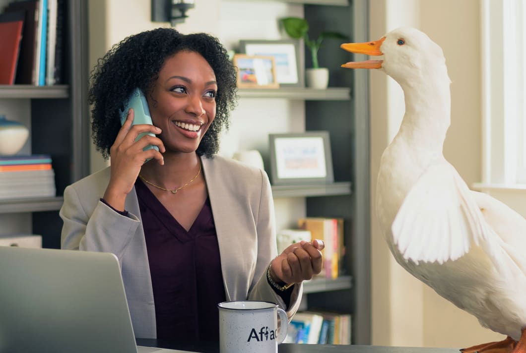 The Aflac Duck helping an agent with a phone call