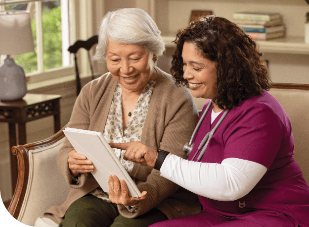 a person with a nurse looking at a tablet