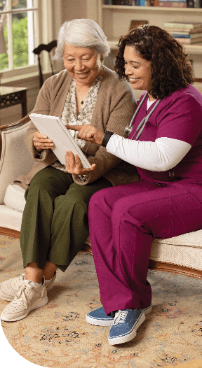 a person with a nurse looking at a tablet