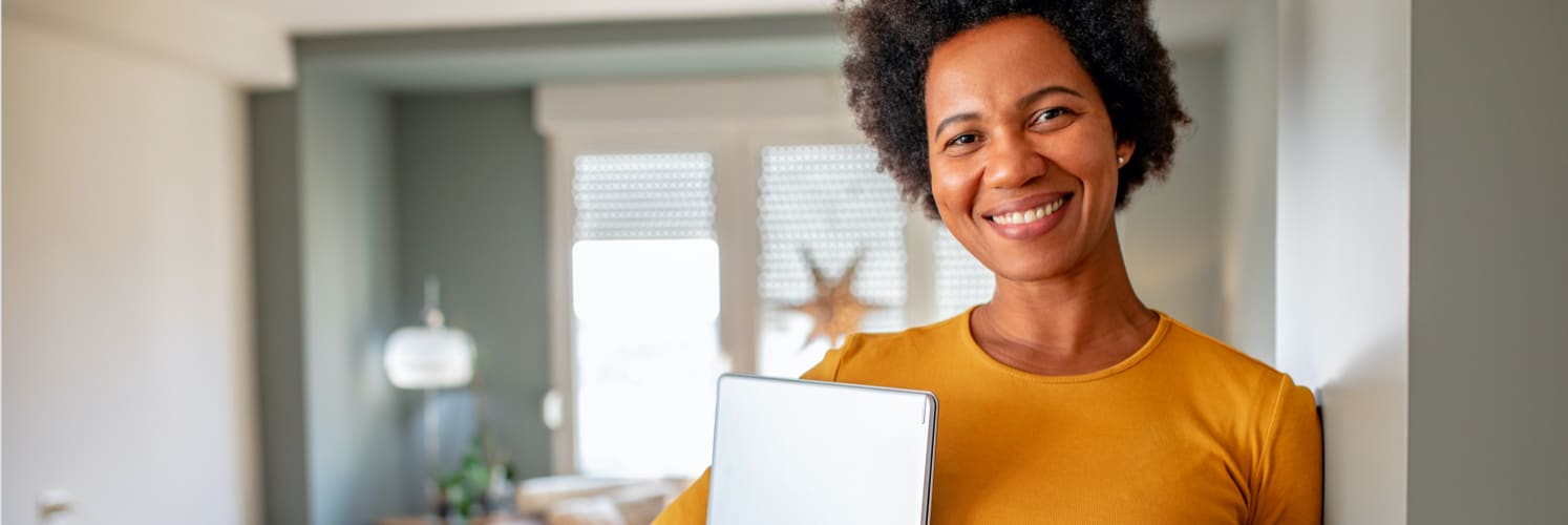 woman laughing and holding laptop