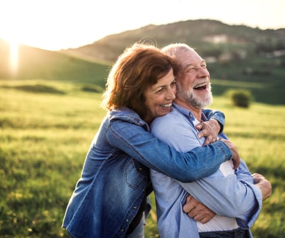 Woman hugging an elderly man from behind