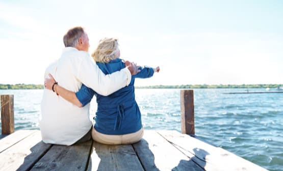 People looking over a lake while sitting on a dock