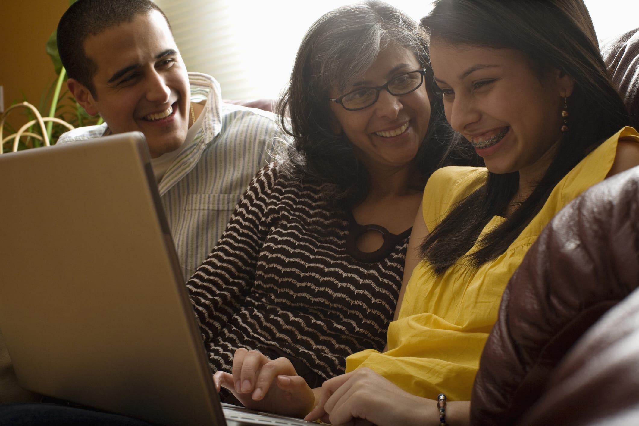 Hispanic Family Laughing With Laptop