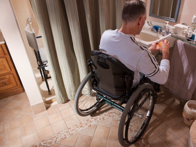 Man uses wheelchair in bathroom remodeled for accessibility