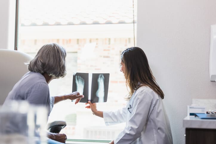 Podiatrist reviews foot x-rays with her patient