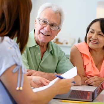 Happy couple smile while speaking with an expert advisor