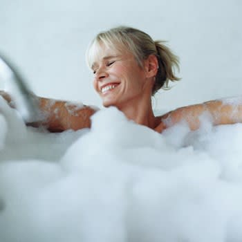 Smiling woman in bath tub