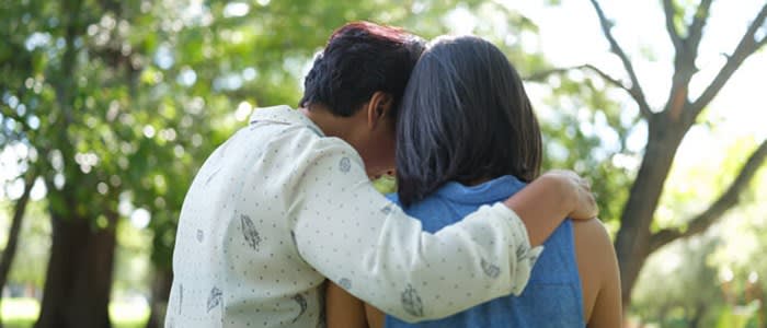 Rear view of two women comforting each other with embrace