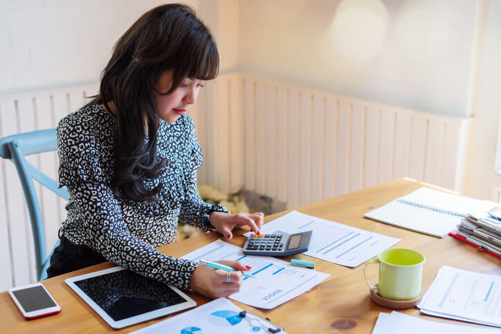 Woman using calculator to determine costs