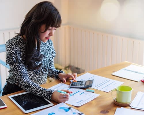 Woman using calculator to determine costs