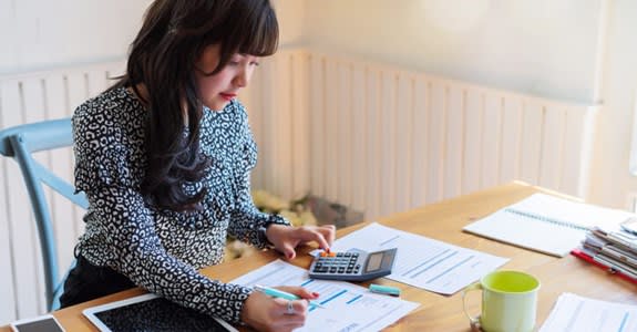 Woman using calculator to determine costs