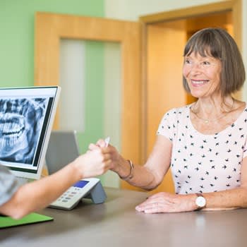 Woman uses insurance card for dental x-rays