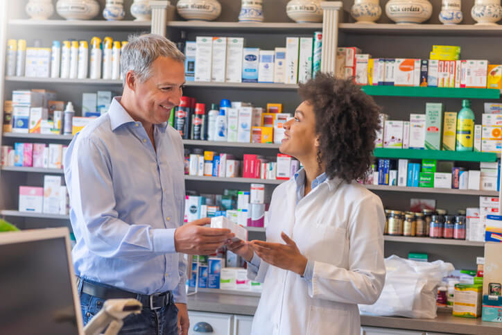 Smiling pharmacist helping customer at pharmacy