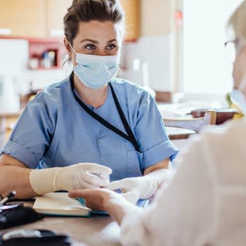 Nurse wearing a mask takes blood for patient