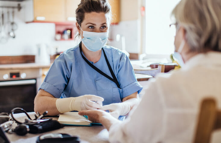 Nurse wearing a mask takes blood for patient