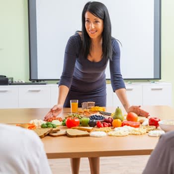 Nutritionist dietitian lays out healthy foods on table for clients