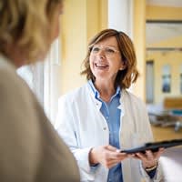 Doctor smiles while reviewing information with her patient