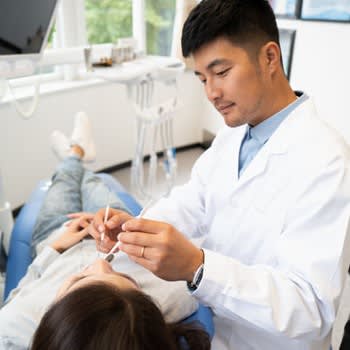 Dentist examines patient in dentist chair