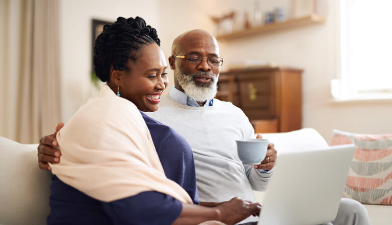 A couple uses their laptop computer while having coffee