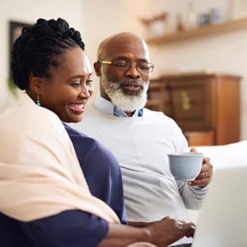 A couple uses their laptop computer while having coffee