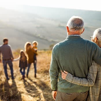 Grandparents Embrace And Gaze At Family