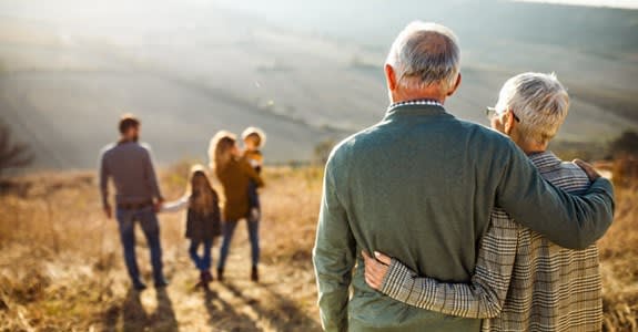 Grandparents Embrace And Gaze At Family