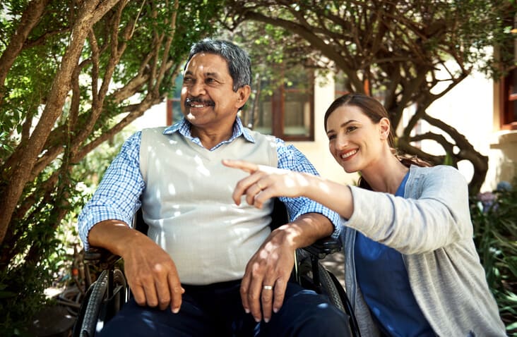 Caregiver points to something while spending time outside with patient