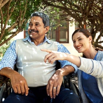 Caregiver points to something while spending time outside with patient