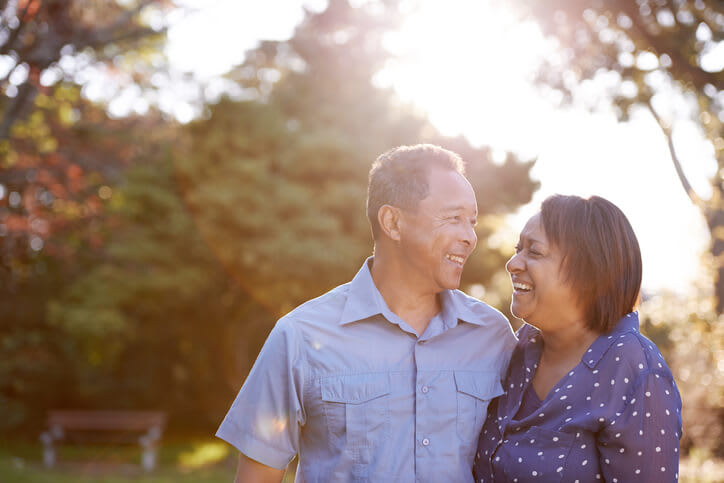 Smiling couple outdoors with sun in the background