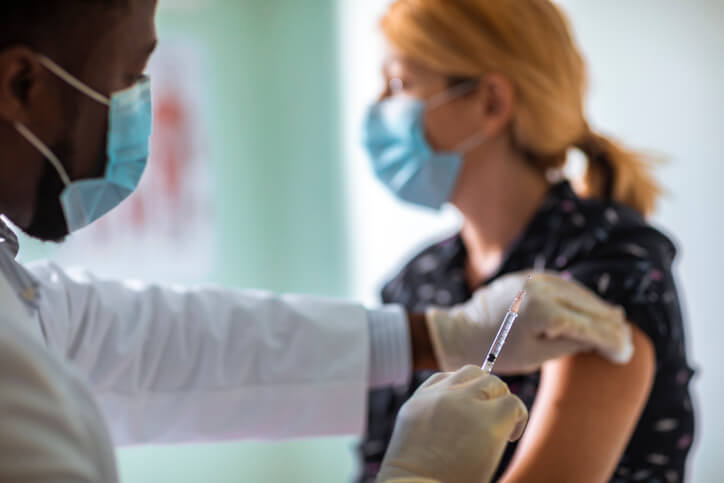 Doctor administers flu shot vaccination to patient