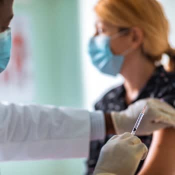 Doctor administers flu shot vaccination to patient