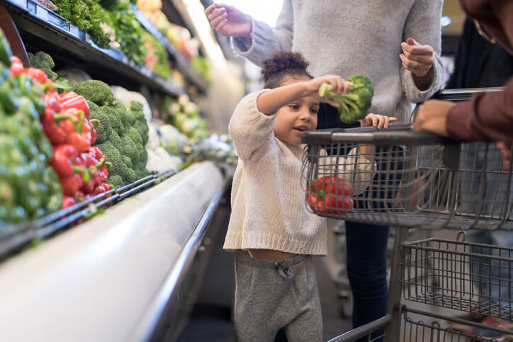 Girl Puts Produce In Grocery Cart