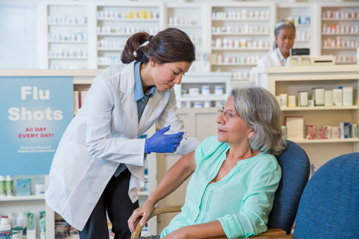 Pharmacist gives flu shot in the pharmacy